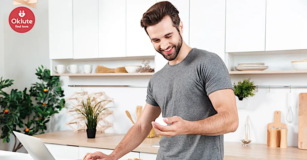 Hombre con barba utilizando notebook y sonriendo